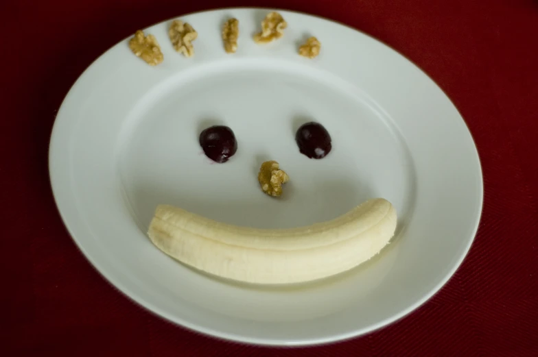 this is a white plate with cherries and a banana