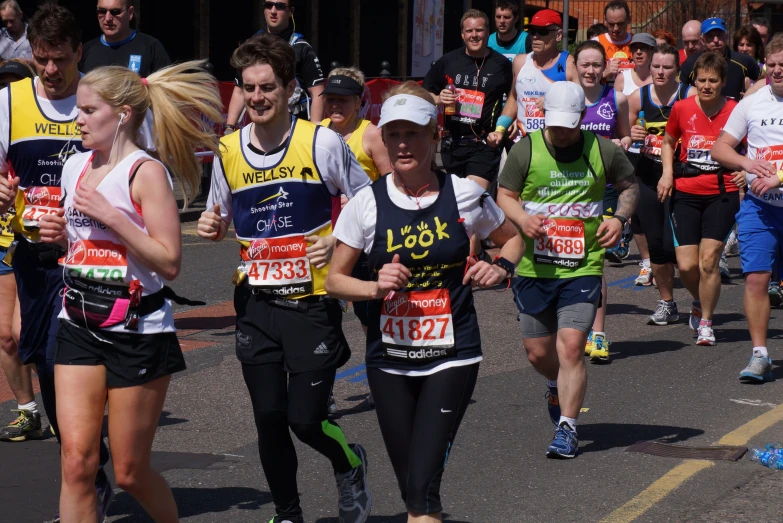 a group of marathon runners running down a street