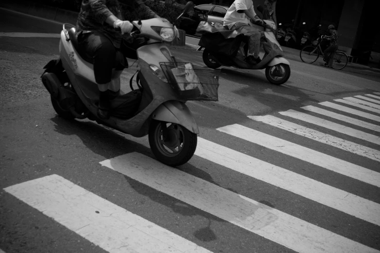 motor scooters on a city street near ze crossing