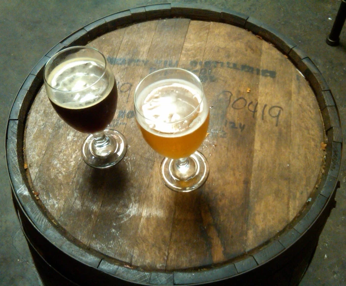 two beers sitting on top of wooden barrels