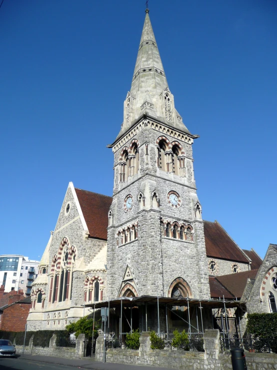 a very tall, stone church tower rises above the streets