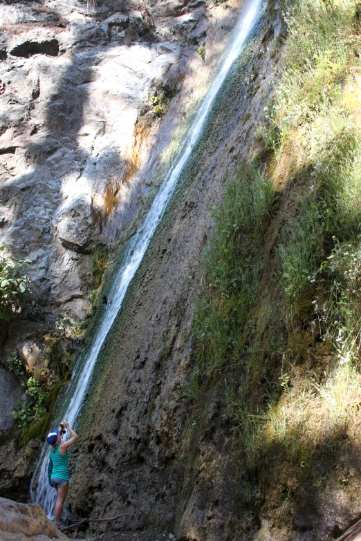 a person standing on rocks next to a cliff