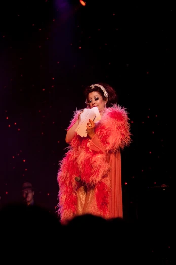 woman in red feather dress and headpiece on stage
