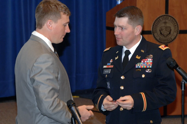 two men in uniforms and microphones talking