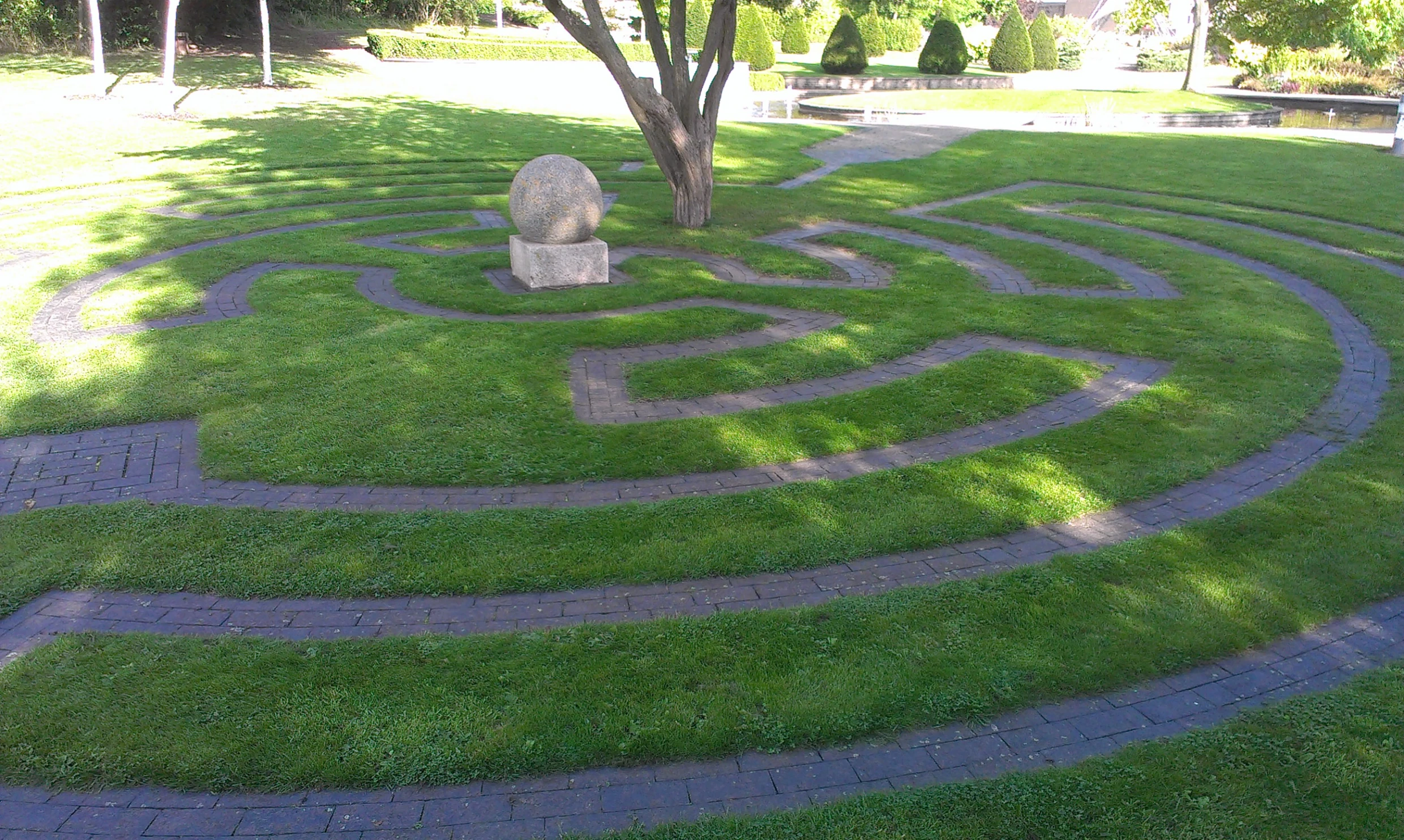 the stone sculpture is next to a tree