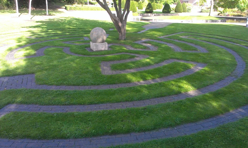 the stone sculpture is next to a tree