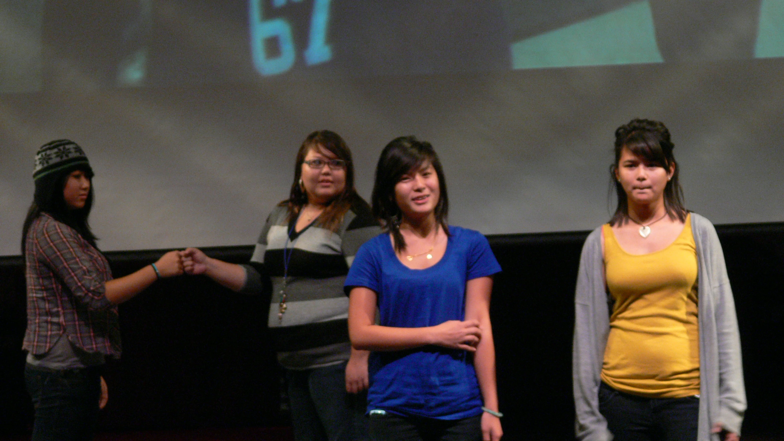 the women are standing on stage singing to the music