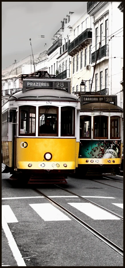 a yellow streetcar driving down a street past a tall building