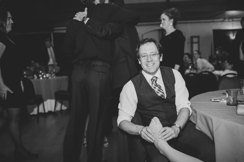 a smiling man sitting down in a chair