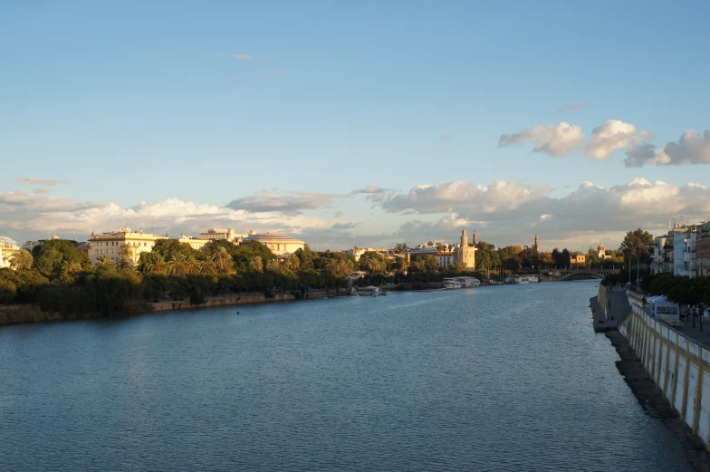 a river is next to some old buildings on the shore