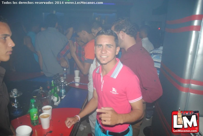 the man in pink shirt has two drinks on the table