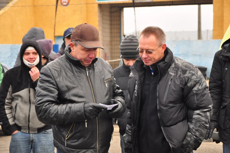 several men are looking at their cell phones