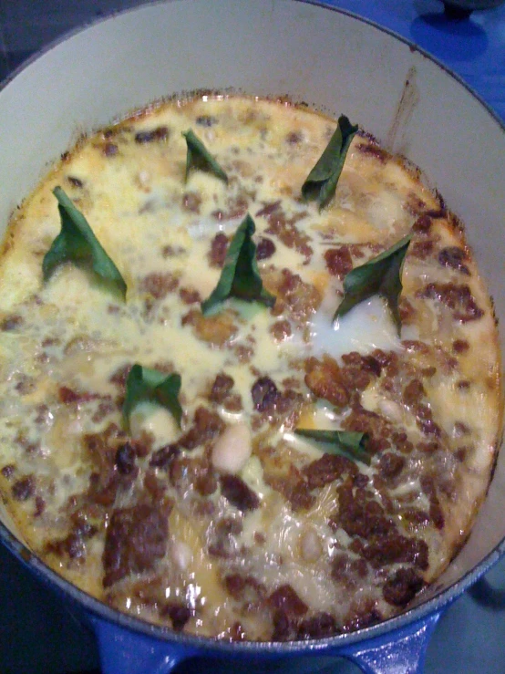 pizza in a pan with green herbs on top