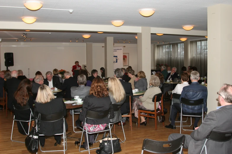 several people seated at tables in an indoor area