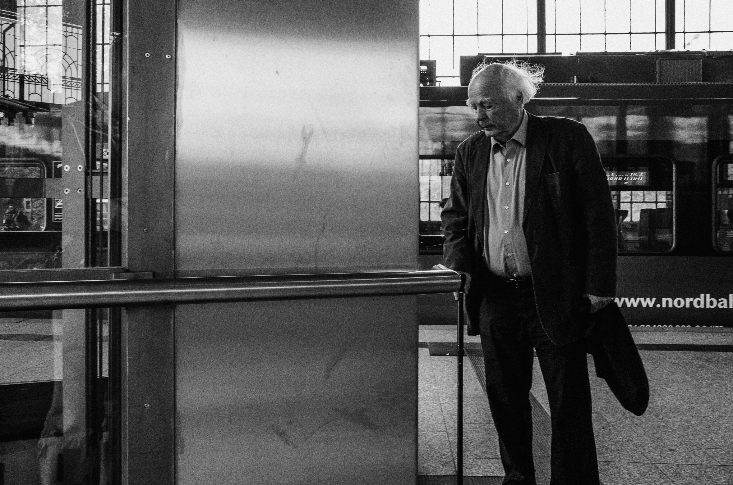 black and white po of a man standing at a subway stop