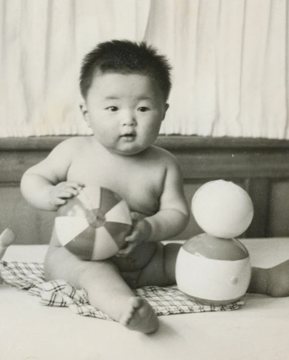 an old po of a baby sitting next to his stuff