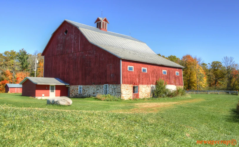 a barn in the middle of a grass field