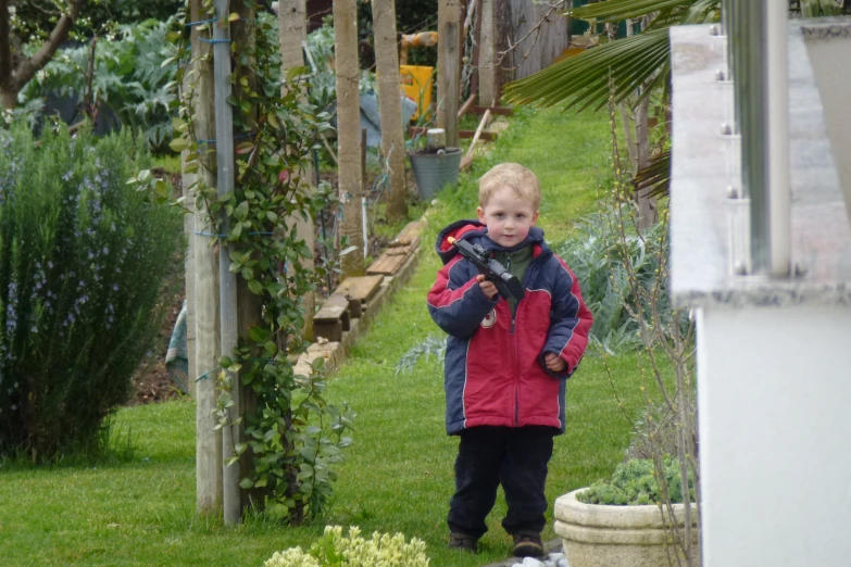 the boy is in a red jacket holding a glove