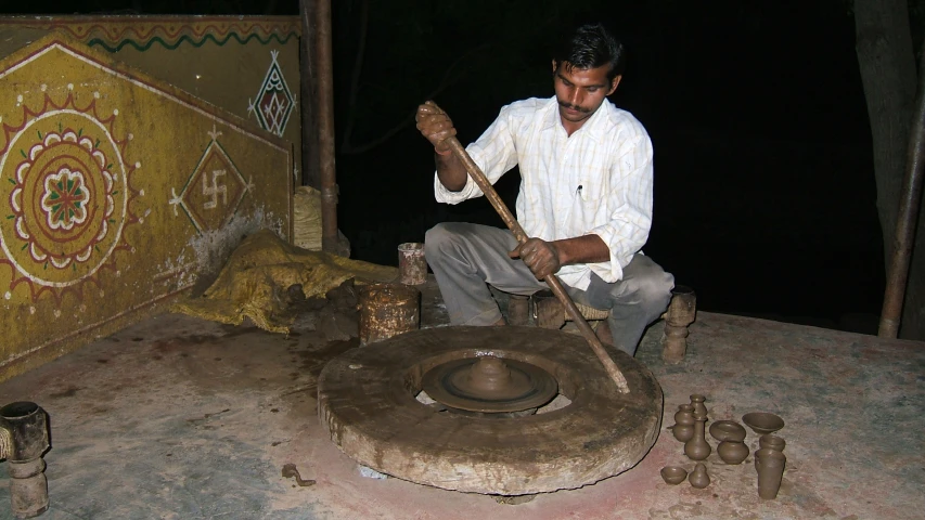 a man mixing metal with a mortar in his hands