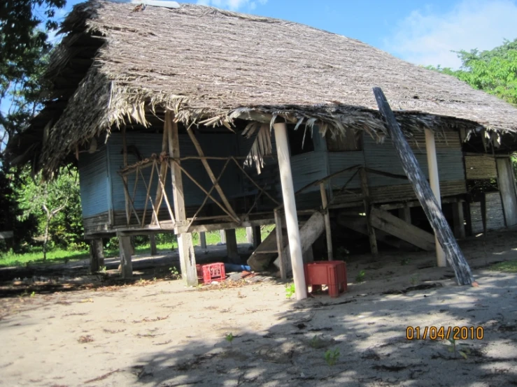 a woman with her dog standing in front of an old hut