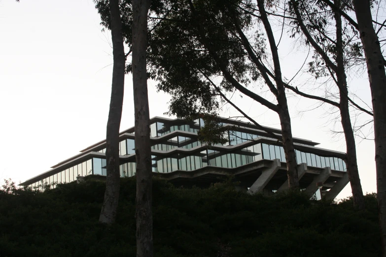 a building sitting on the top of a hill surrounded by trees