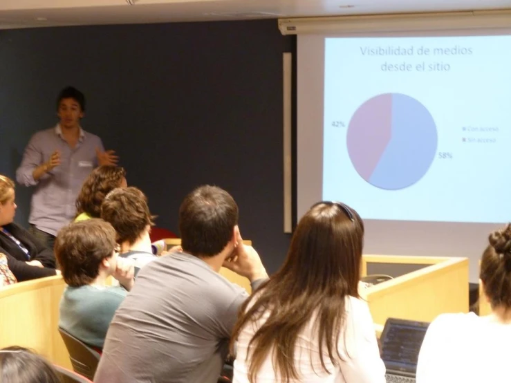 a man talking to people in a classroom