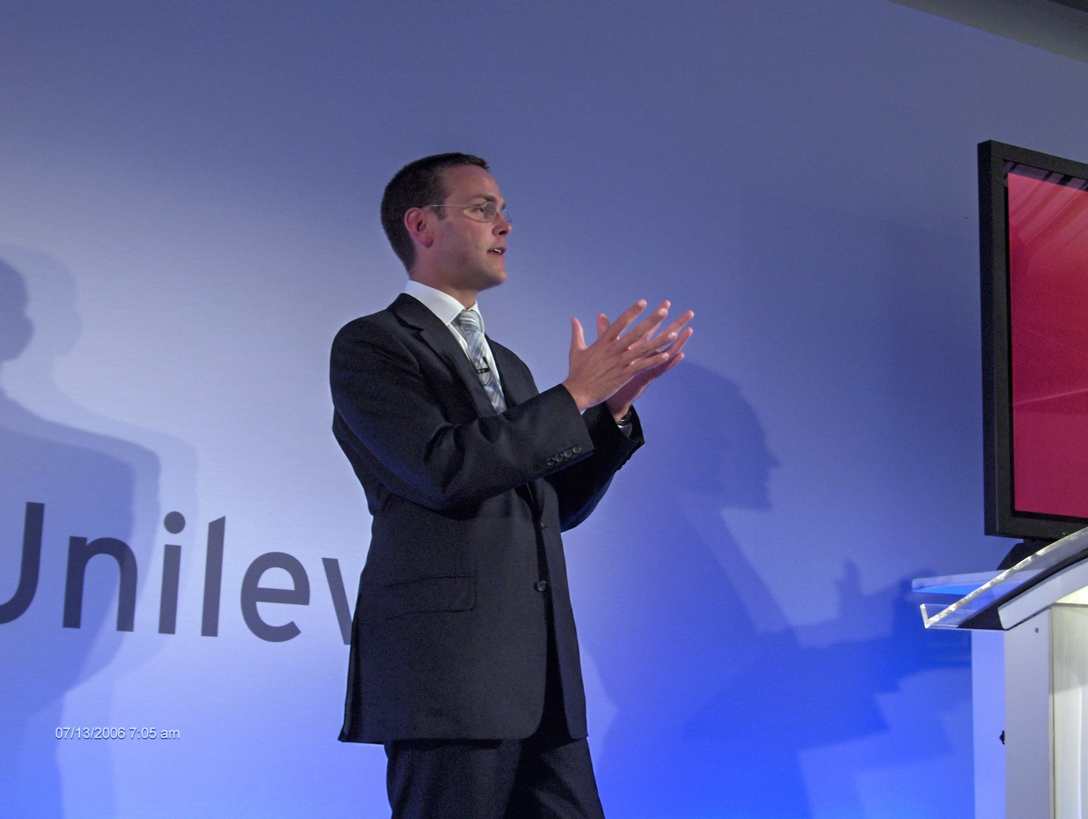 man standing in front of a podium speaking at an event