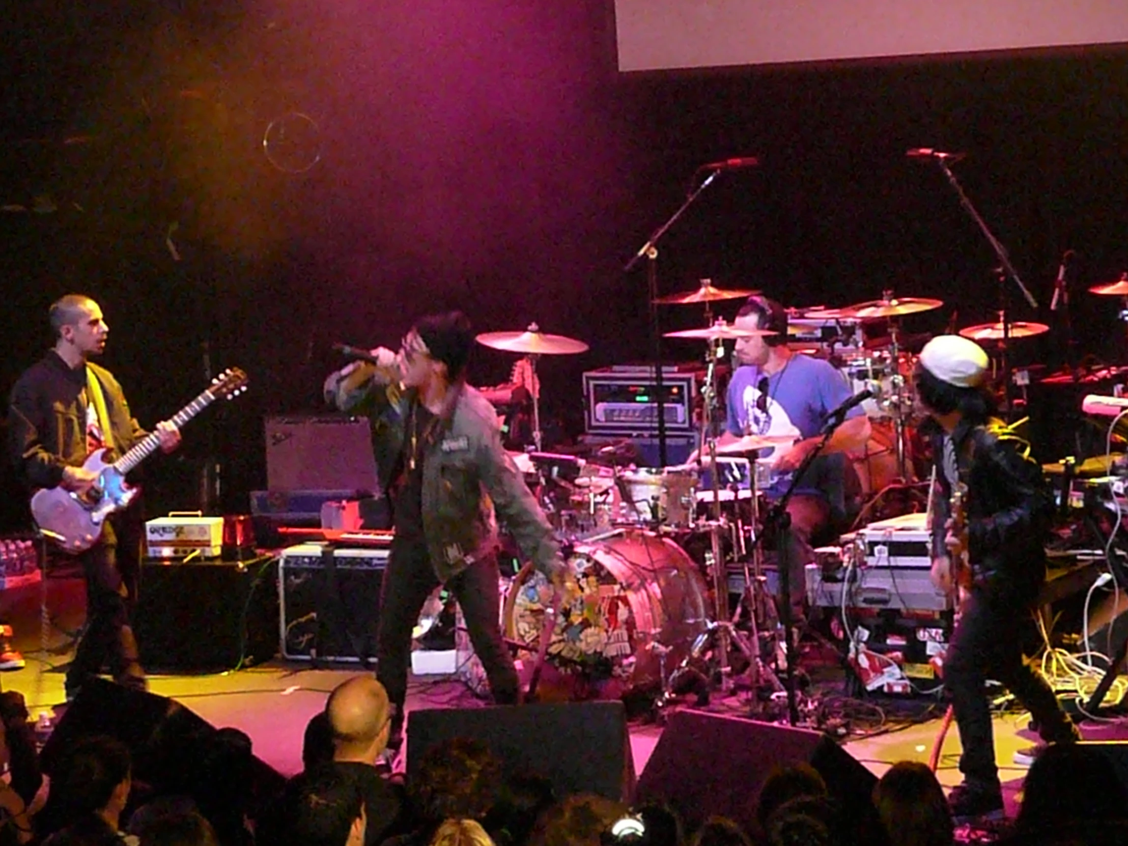 a crowd of people standing around a concert stage