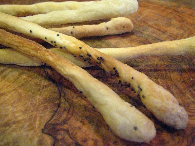 four homemade bread sticks in a bowl and sitting on a table