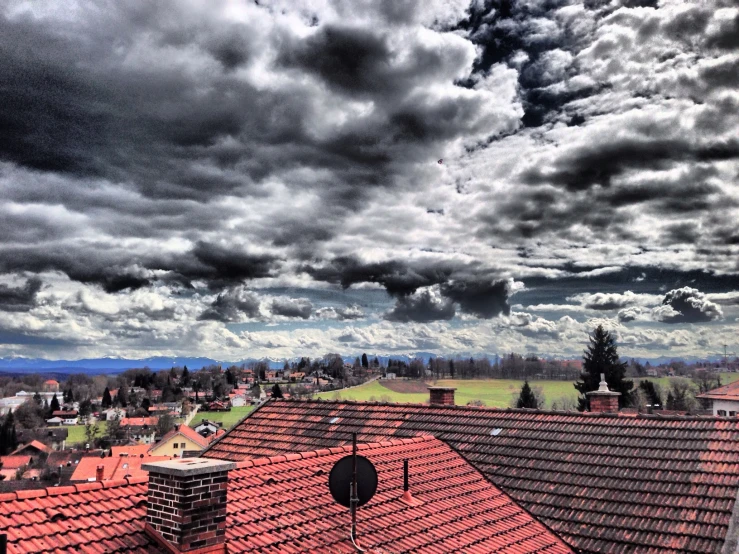 clouds in the sky over the rooftops of a residential neighborhood