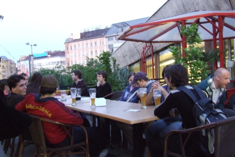 a group of people sitting at a restaurant table drinking