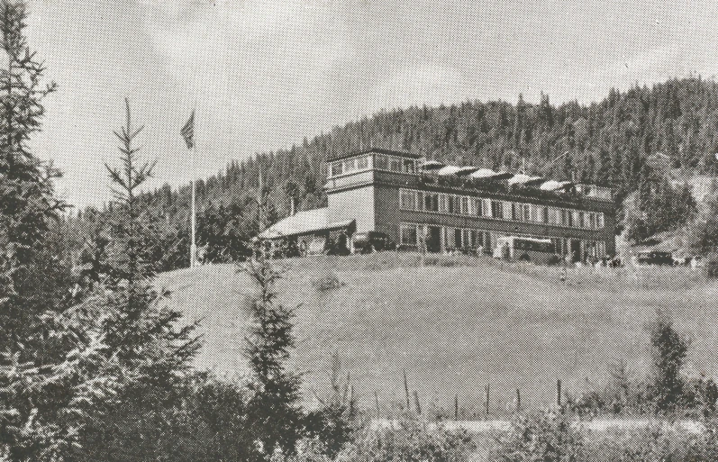 an old black and white pograph of a house on top of a hill