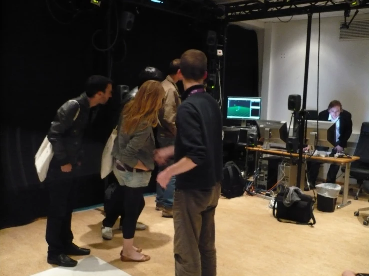 several people in front of a tv and equipment