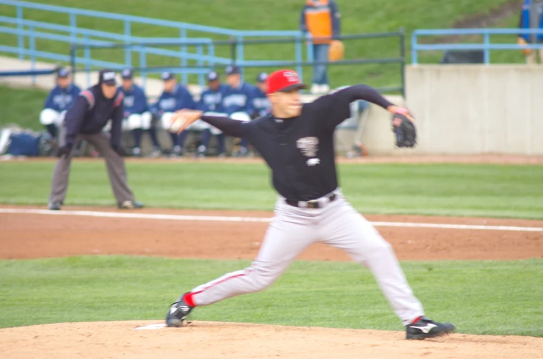 a baseball player pitching the ball on top of a field