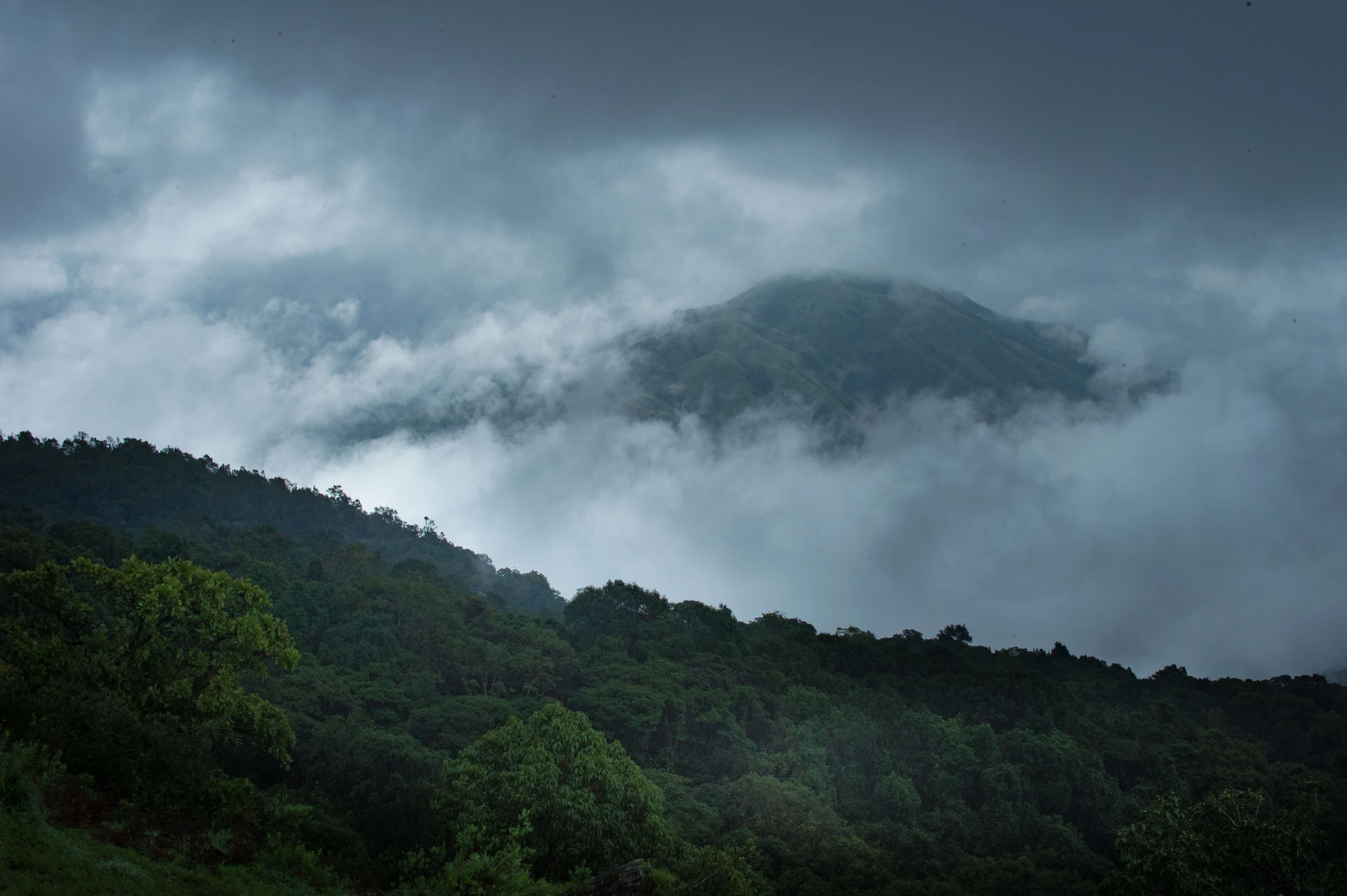 a very tall mountain covered in clouds and fog