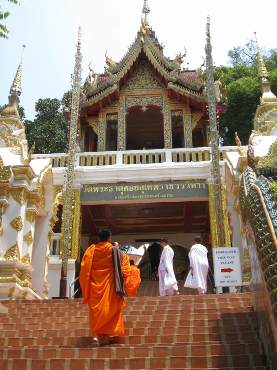 people are walking up stairs in front of a pagoda