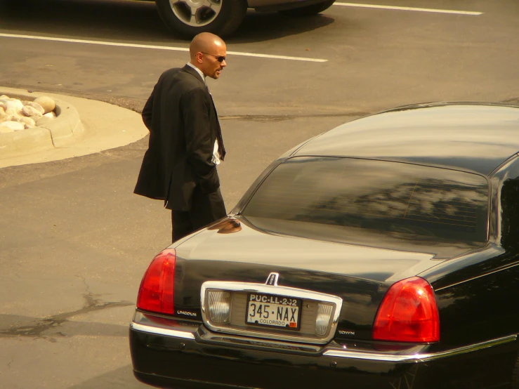 a man walking in the road near a car