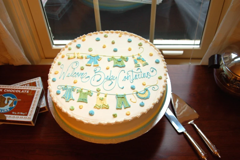 a large cake with white frosting and baby boy pictures on it