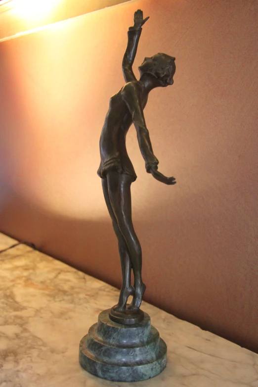 a woman statue in the shape of a boy holding his hand up