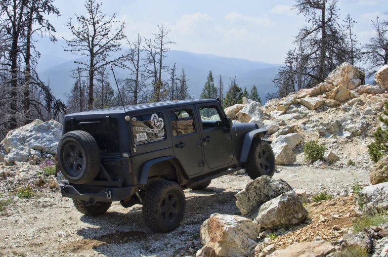 a black jeep driving down a rocky mountain side