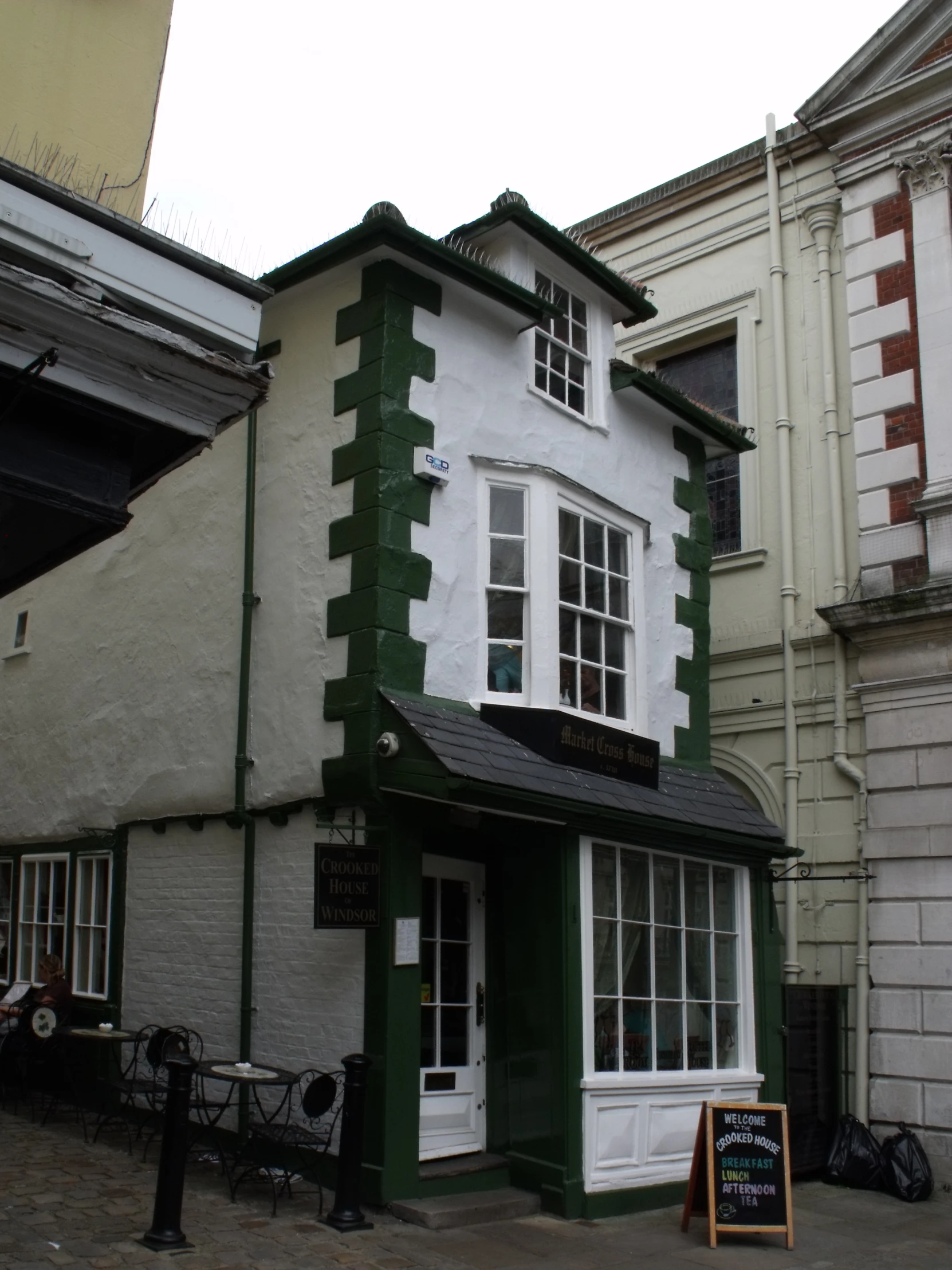 a small store front with a green and white striped building