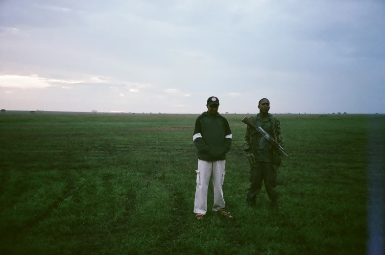 two men are standing in an open field