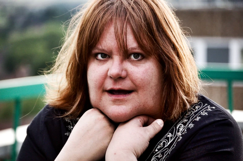 a close - up portrait of a woman, with her hands on her chin