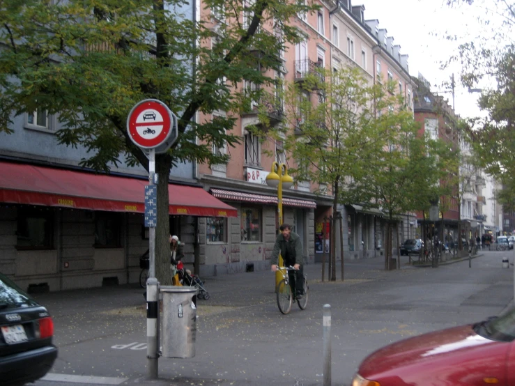 an intersection with street signs, traffic light and cars