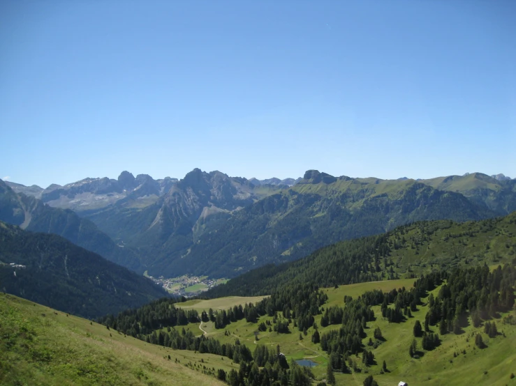 a couple of large hills with mountains in the background