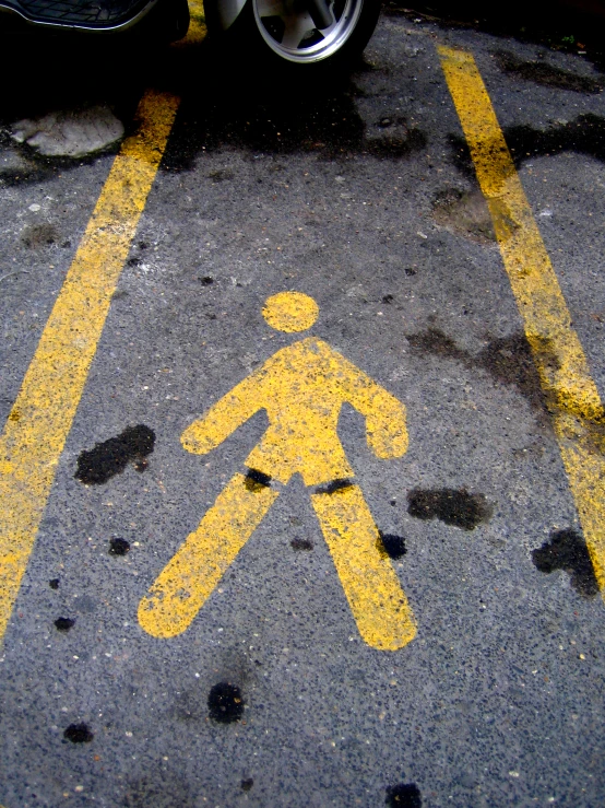 a yellow pedestrian crossing signal on the ground