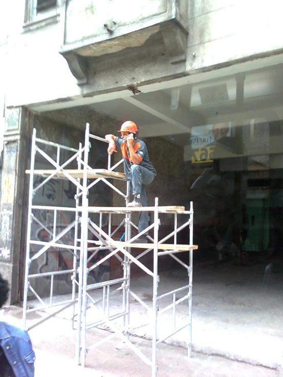 a construction worker taking measurements to the area surrounding the building