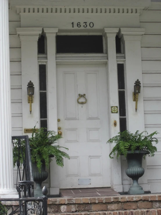 a white door on an old house with flowers