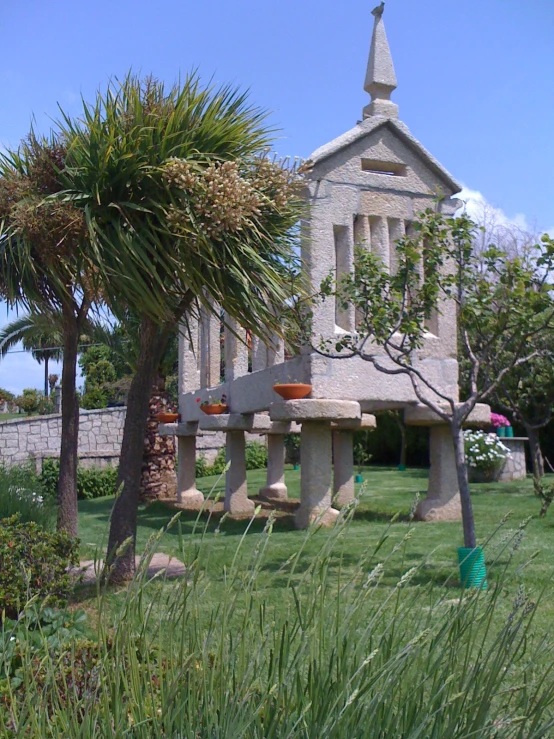 an old church sits behind a palm tree in a garden