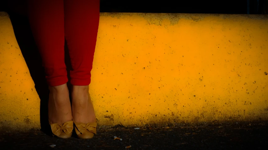 the legs of a woman standing on the wall with a black background